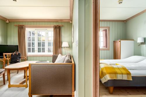 a bedroom with a mirror and a bed and a table at Ilsetra Hotell in Hafjell