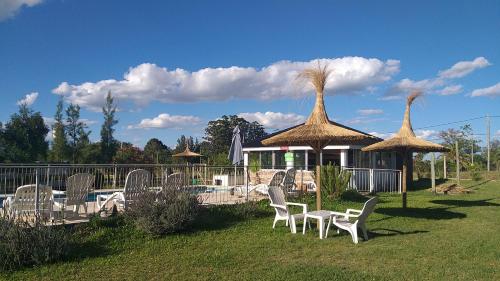 a group of chairs and umbrellas next to a pool at Los manzanos . in Colón