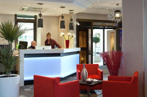 a woman sitting at a counter in a lobby at Allobroges Park Hôtel in Annecy