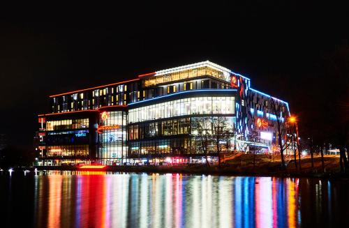 een gebouw verlicht met lichten op het water in de nacht bij Genting Hotel & Spa at Resorts World Birmingham in Bickenhill