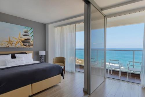 una camera con letto e vista sull'oceano di Resort Hadera by Jacob Hotels a Hadera