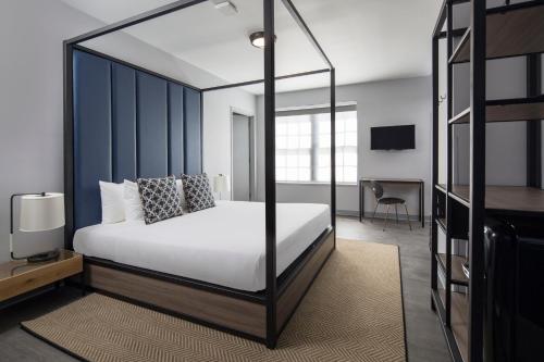 a bedroom with a white bed with a black frame at Generator Miami in Miami Beach