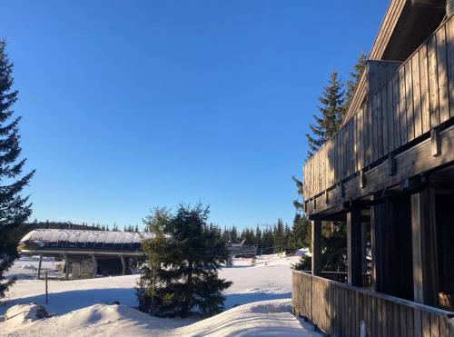 a building in the snow next to a ski slope at Apartment with Electric car charger ski in out in Sjusjøen