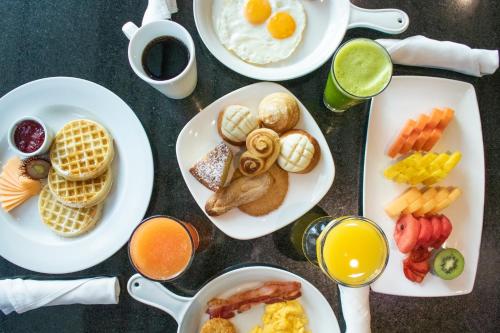 una mesa con platos de comida y bebida para el desayuno en Holiday Inn Guatemala, an IHG Hotel, en Guatemala