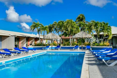 basen z leżakami i parasolami w ośrodku w obiekcie Aruba Blue Village Hotel and Apartments w Palm Beach