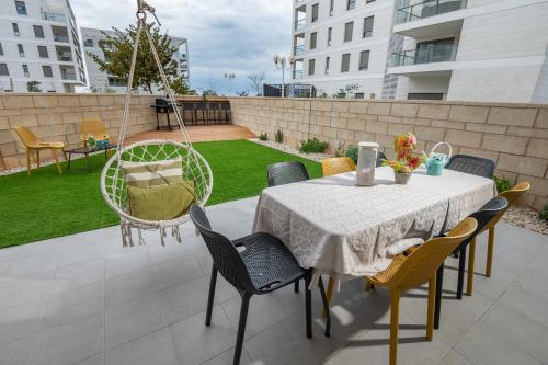 eine Terrasse mit einem Tisch und Stühlen sowie einem Hof in der Unterkunft Achziv Sea&Sun in Naharija