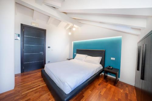 a bedroom with a white bed and a blue wall at SIRIOHotel in Dormelletto