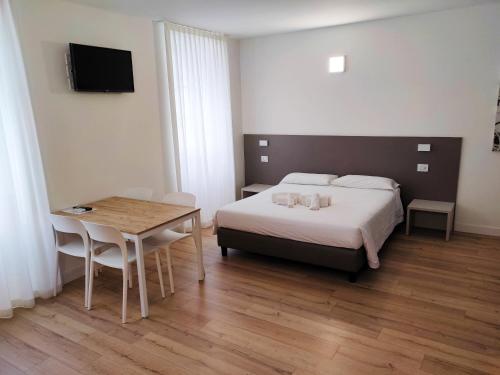 een slaapkamer met een bed, een tafel en een televisie bij City Gallery Apartments in Trieste