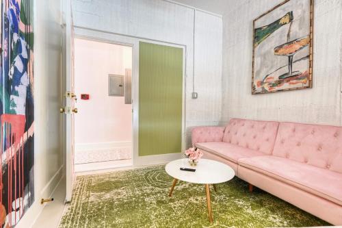 a living room with a pink couch and a table at The Oleander Hotel Room 6 in Galveston