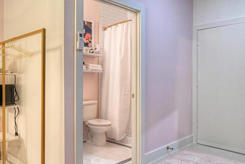 a bathroom with a toilet and a shower with a mirror at The Oleander Hotel Room 6 in Galveston