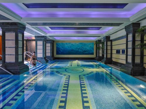 uma piscina num hotel com uma mulher a andar nela em Killarney Plaza Hotel & Spa em Killarney