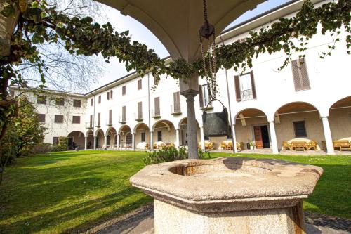 a large building with a stone fountain in the yard at Hotel Il Chiostro by LVG Hotel Collection in Verbania