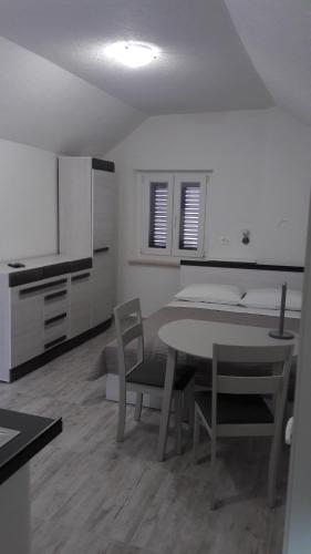 um quarto com uma mesa e cadeiras e uma cama em EMA HOUSE em Zadar