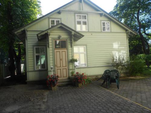 une maison verte avec une porte et une terrasse dans l'établissement Poska Villa Guesthouse, à Tallinn