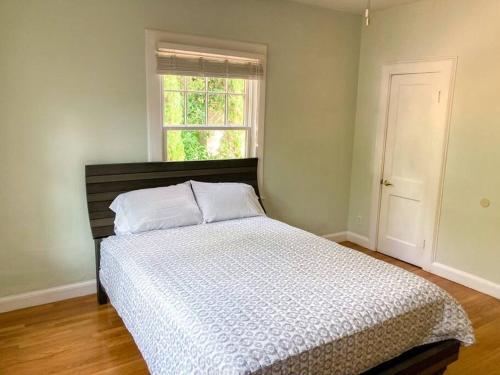 a bedroom with a large bed with a window at University House - 8 Bedrooms Walk to UF / Stadium in Gainesville