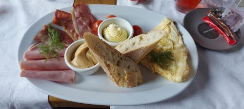 ein Frühstücksteller mit Eiern, Schinken und Toast in der Unterkunft Pensiunea Clasic in Buşteni