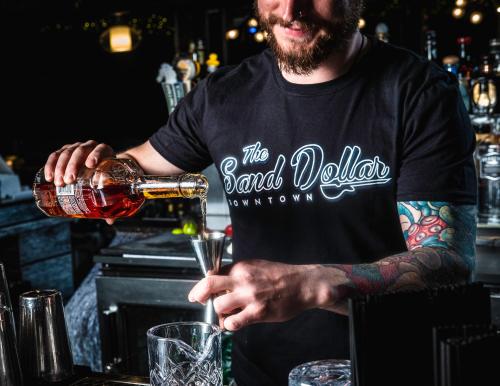 a man pouring a drink into a glass at Plaza Hotel & Casino in Las Vegas