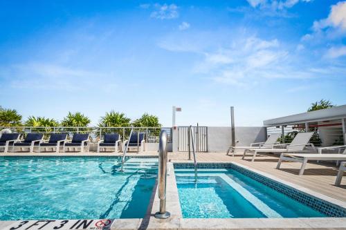 a swimming pool with lounge chairs next to a building at Bay Harbor One Vacation in Miami Beach