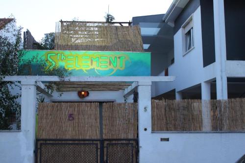 ein Gebäude mit einem Tor mit einem Schild darauf in der Unterkunft 5th Element Beach House Caparica in Costa da Caparica