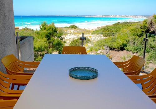 un tavolo con un piatto e vista sulla spiaggia di Apartments Es Trenc a Ses Covetes