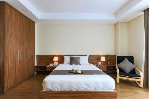 a bedroom with a large bed and a chair at Aurora Serviced Apartments in Ho Chi Minh City