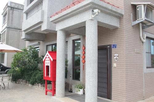 a red house in front of a building at 八八小屋心享民宿 in Jinning