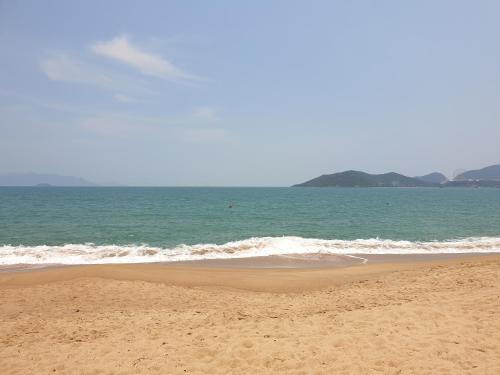 une plage de sable avec l'océan en arrière-plan dans l'établissement VANDA Hotel Nha Trang, à Nha Trang