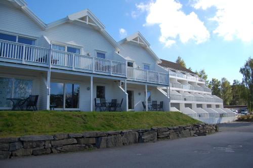 a large white building with a stone wall in front of it at Hamresanden Resort in Kristiansand