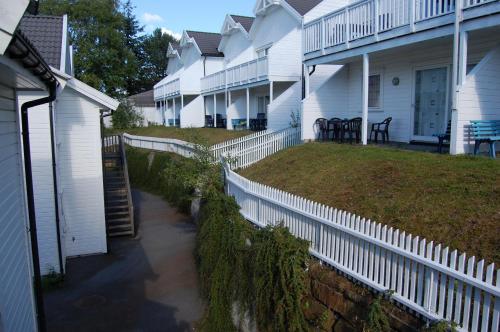 a row of white houses with a white fence at Hamresanden Resort in Kristiansand