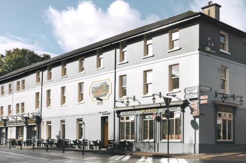 um grande edifício branco na esquina de uma rua em The Bianconi Inn em Killorglin