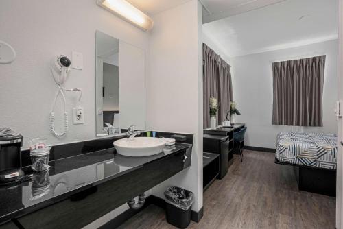 a bathroom with a sink and a large mirror at Motel 6-San Diego, CA - Downtown in San Diego