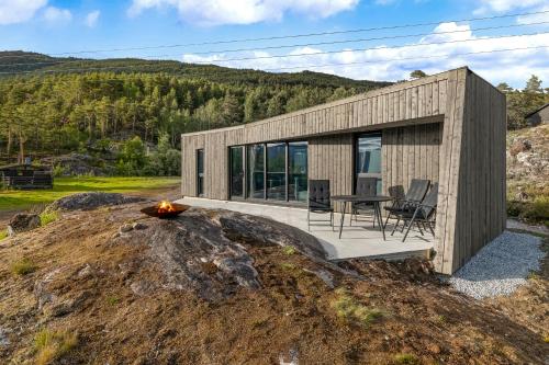 uma pequena casa de madeira numa colina com uma lareira em Sogndal Fjordpanorama em Sogndal