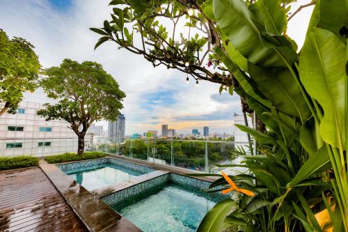 una piscina in un giardino con vista sulla città di Cochin Sang Hotel ad Ho Chi Minh