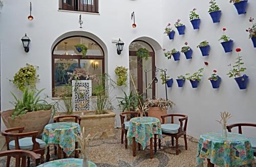 un patio con mesas, sillas y macetas en Hotel Marisa, en Córdoba