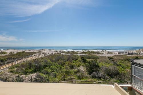 uitzicht op het strand vanaf het balkon van een huis bij ICONA Windrift in Avalon