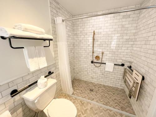 a white bathroom with a toilet and a shower at EXchange Hotel Vancouver in Vancouver