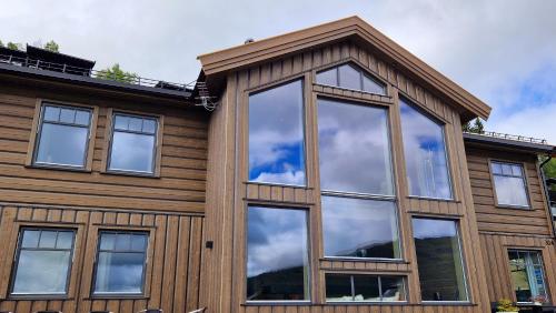 uma casa com janelas que refletem o céu em Mlodge - The Mountain Lodge em Sogndal