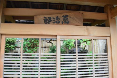 a room with a window with a view of a garden at Yadoya Manjiro in Kyoto