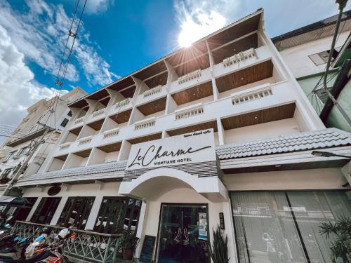 un edificio blanco con un cartel. en Le Charme Vientiane Hotel, en Vientiane