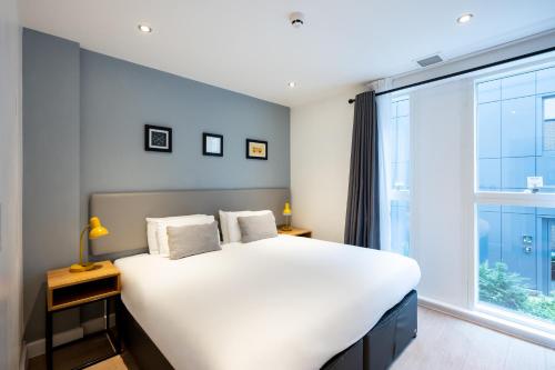 a bedroom with a large bed and a large window at Staycity Aparthotels Birmingham Jewellery Quarter in Birmingham