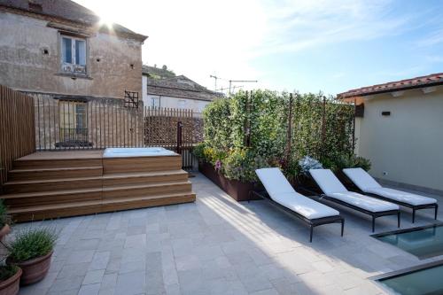 a patio with two chairs and a bench on it at Dimora de Matera Luxury Suites in Cosenza