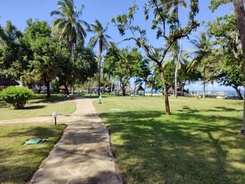 un sendero en un parque con palmeras en Cocoa Luxury Resort, Nyali, Mombasa, en Mombasa