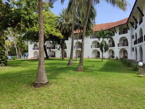 un edificio con palmeras delante en Cocoa Luxury Resort, Nyali, Mombasa, en Mombasa