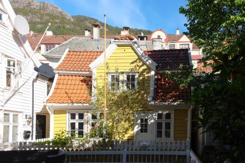 a yellow house with orange roofs in a city at Charming Bergen house, rare historic house from 1779, Whole house in Bergen