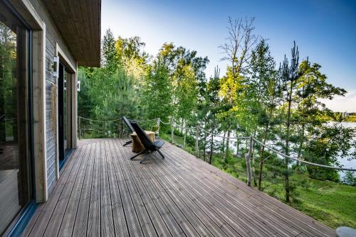 une terrasse en bois avec un banc sur une maison dans l'établissement Lapsu ciems, à Sece