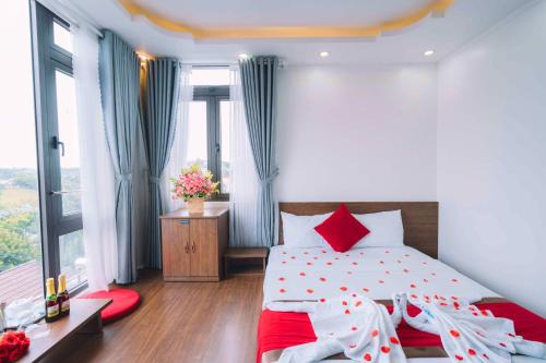 - une chambre avec un grand lit et des oreillers rouges dans l'établissement Le Tuan Minh Hotel, à Đà Lạt