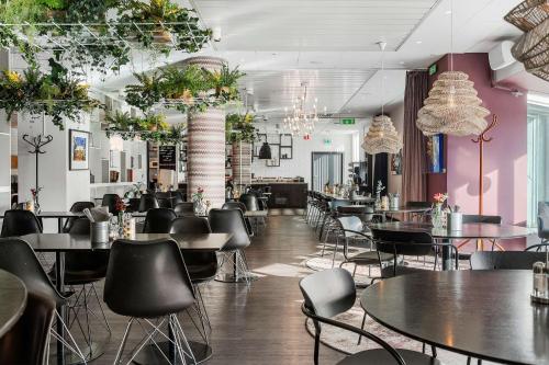 un restaurante con mesas, sillas y paredes rosas en Best Western Plus Hotel Plaza, en Västerås