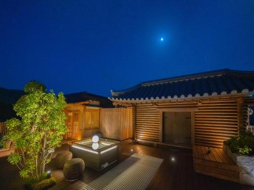 ein Haus mit einer Terrasse in der Nacht mit dem Mond in der Unterkunft Hotel New Wakasa in Nara