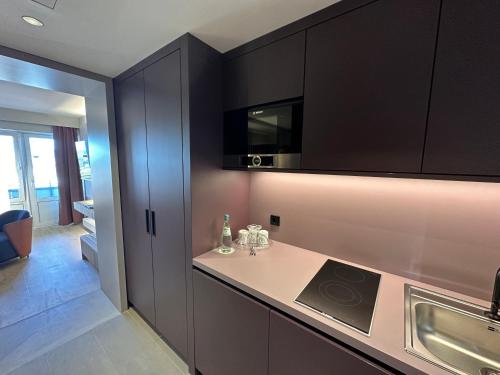 cocina con armarios negros y encimera en Apartment-Hotel Hamburg Mitte, en Hamburgo