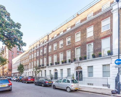 Cleveland Residences Russell Square في لندن: مبنى كبير من الطوب فيه سيارات متوقفة أمامه